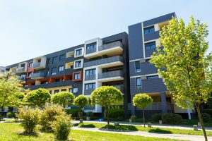 Exterior of a modern black apartment buildings on a blue sky background. No people. Real estate business concept.